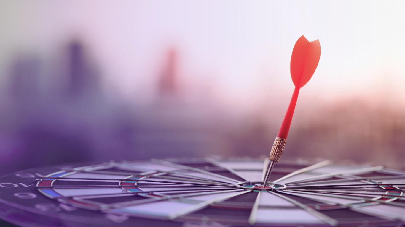 Dardo rosso che colpisce il centro di un bersaglio per freccette. Simboleggia la precisione e il raggiungimento del cliente giusto tramite la SEO Locale.